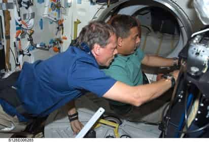 El astronauta de origen mexicano José Hernández, y el de la agencia espacial europea Christer Fuglesan (izquierda), trabajan juntos en el transbordador Discovery durante el segundo día de actividades de la misión a la Estación Espacial Internacional.