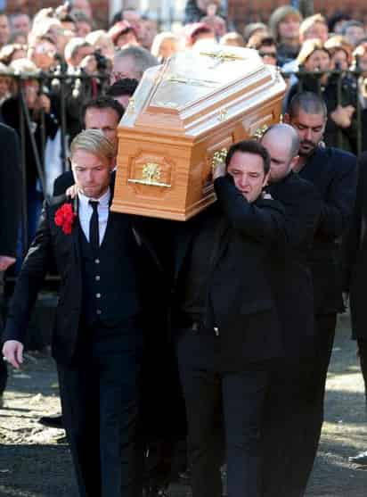 Tristeza. Miembros del grupo Boyzone, Ronan Keating (izq.) y Keith Duffy (der.), y familiares de Stephen Gately, cargaron los restos del músico. EFE