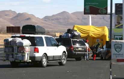 Con la bendición. Los paisanos se encomiendan a todos los santos en su travesía de regreso a México, ante la ola de violencia que sacude al país.