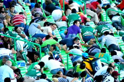 Pecho tierra. Aficionados se resguardan entre las butacas durante la balacera. A la izquierda de la imagen, Oribe Peralta cubre a su esposa.