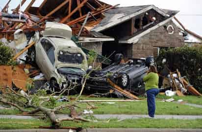 Viento. Una mujer observa el daño que causaron los fuertes tornados en Texas, en la imagen dos autos destruyeron su vivienda debido a los fuertes vientos.