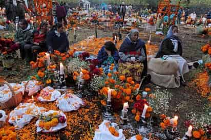 Festejo.  También en la ribera del Lago de Pátzcuaro, Michoacán,  familiares y amigos reciben a sus muertos con ofrendas, música y flores, en el marco de la celebración del Día de Muertos.