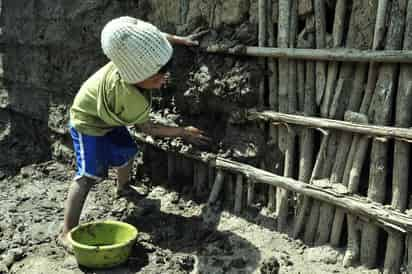 Desarrollo. Un pequeño de cinco años ayuda a construir su vivienda hecha con palos y lodo. Según el reporte de la Cepal, las mujeres y los niños son los más vulnerables a la pobreza en América Latina. (NOTIMEX)