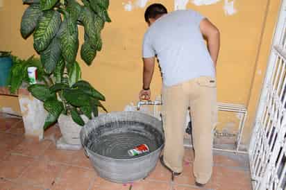 ‘Lo que caiga’. En la calle Simón Bolívar de la colonia Moderna, los vecinos dejan la llave abierta día y noche para almacenar un poco de agua. Tienen 15 días que no sale absolutamente nada. (Fernando Compeán)