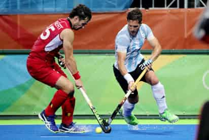 El argentino Agustín Mazzilli (d) disputa la pelota con el belga Loick Luypaert (i), durante el partido por la final de hockey sobre césped. (EFE)