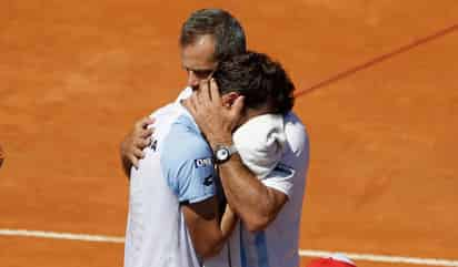 Guido Pella (i) recibe consuelo del capitán del equipo argentino, Daniel Orsanic, luego de perder el punto decisivo. (AP)