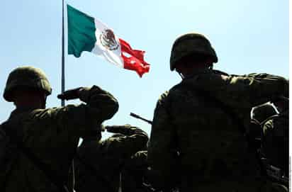 Un reflejo. Los militares rindieron honores a la bandera que se rasgó al momento de izarla.