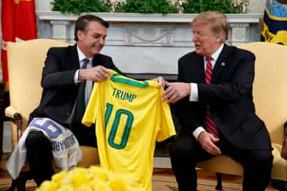 Hubo espacio para las bromas, cuando ambos intercambiaron camisetas de sus respectivas selecciones de fútbol con sus nombres en el dorsal y Trump destacó la leyenda de ese deporte que fue Pelé. 'Yo soy un poco más joven, pero también recuerdo a Pelé', replicó Bolsonaro. (AP)