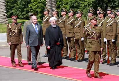 El presidente de Irán, Hasán Rohaní (c), pasa revista a la guardia de honor acompañado por su homólogo iraquí, Barham Salih. (ARCHIVO)