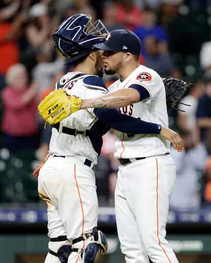 Roberto Osuna (d) festeja con Robinson Chirinos tras la victoria de los Astros 6-4 sobre Reales de Kansas. (AP)