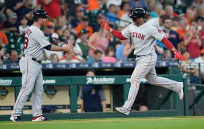 Rafael Devers (d) celebra con el coach de tercera base, Andy Barkett, tras conectar un cuadrangular en el juego de ayer. (AP)