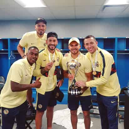 Los elementos de las Águilas festejan en los vestidores con el trofeo del Campeón de Campeones que ganaron ante los Tigres. (ESPECIAL)