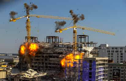 Las dos grúas resultaron bastante dañadas cuando los pisos superiores del hotel se derrumbaron uno sobre otro, lanzando escombros a la calle y generando nubes de polvo. (AP)