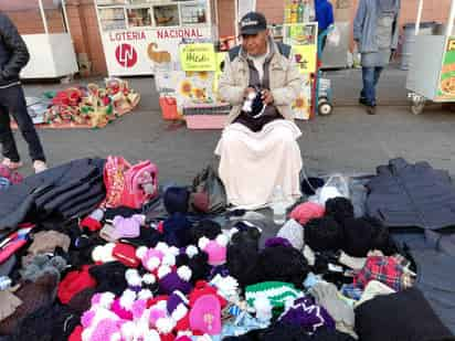 Tejiendo gorras, Jesús Antonio comentó que cada año visita la región para la venta de todo tipo de prendas abrigadoras para los laguneros, las cuales teje personalmente junto con su familia. (EL SIGLO DE TORREÓN)