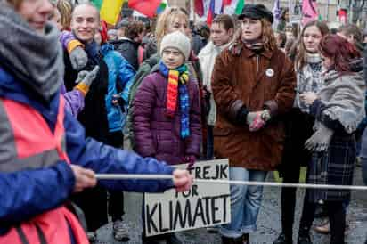 La comitiva avanzó lenta bajo la lluvia de Bruselas con Thunberg a la cabeza, colocada estratégicamente dentro de un doble cordón de seguridad en el que policías y activistas se unieron formando una cadena humana. (EFE)