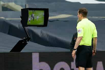 El árbitro Peter Bankes observa en un monitor una mano de Eric Dier, quien estaba de espaldas, y luego marcó penal, debido a la nueva regla en Europa en la que cualquier mano dentro del área es penal. (AP)