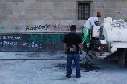 La Secretaría de Hacienda y Crédito Público (SHCP) ha desembolsado más de 200 mil pesos en insumos, pinturas y químicos para limpiar y rehabilitar las paredes y puertas de Palacio Nacional ante las pintas y destrozos que se han realizado en manifestaciones y protestas que terminan frente al recinto histórico, como han sido las movilizaciones por el caso Ayotzinapa o para exigir fin a la violencia feminicida. (ARCHIVO)