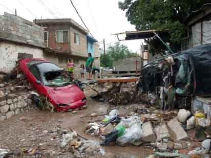 Varios vehículos que estaban estacionados en el arroyo de la México, entre ellos un Camaro y un Volvo, fueron arrastrados por la fuerte corriente varias cuadras. (EL SIGLO DE TORREÓN)