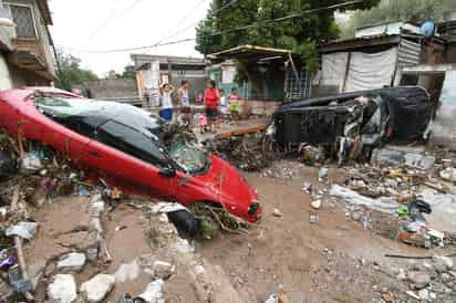 Varios vehículos que estaban estacionados en el arroyo de la avenida México, entre ellos un Camaro, un Volvo y una camioneta, fueron arrastrados por la fuerte corriente de agua varias cuadras. (FERNANDO COMPEÁN)