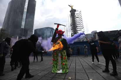 Un grupo de mujeres mexicanas protestó este lunes frente al Ángel de la Independencia, en Ciudad de México, al cumplirse dos años de la gran manifestación en la que pintaron este emblemático monumento con centenares de consignas feministas. (EFE)