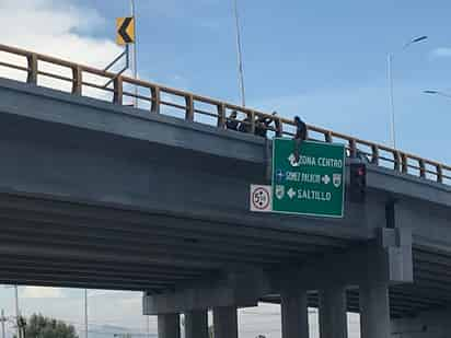 El hombre permaneció cerca de una hora sobre una señalética ubicada en el puente Bravo, mientras los socorristas intentaban ayudarlo. (EL SIGLO DE TORREÓN)