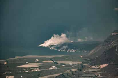 La lava que emana del volcán de la isla española de La Palma cae al agua en un caudal continuo y este jueves sigue ganando terreno al mar, al tiempo que se prevé un deterioro en la calidad del aire por cambios en los vientos. (EFE)

 