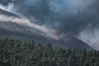 El volcán de la isla española de La Palma, que presenta este viernes una actividad intensa, cuenta con dos nuevas bocas de las cuales manan ríos de lava que buscan unirse a la colada primigenia en su avance hacia el mar. (EFE) 
