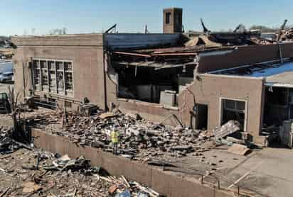 Personal de rescate escarbaba el domingo entre casas y negocios en ruinas tras el paso de un tornado en el estado de Kentucky que arrasó con las construcciones, incluyendo una fábrica de velas que estaba llena de empleados del turno nocturno cuando se vio arrasada. El gobernador advirtió que el número de muertos debido al tornado podría superar los 100. (ARCHIVO) 
