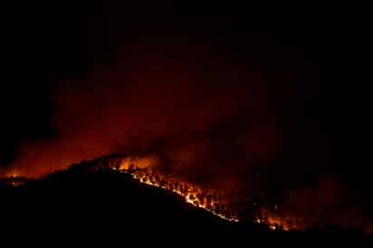 Cientos de bomberos seguían en alerta ante la posibilidad de que los vientos reenciendan las cenizas humeantes. (AP)