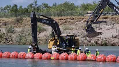 Personal responsable de la colocación de la barrera de boyas marítimas en el cauce del río Bravo trabajar en reforzar el muro. (Foto: RENÉ ARELLANO / EL SIGLO COAHUILA)