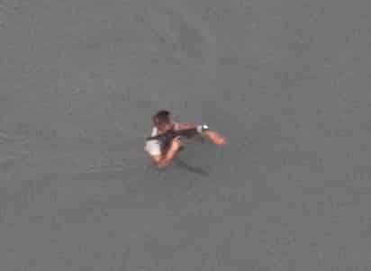 El hombre aparece portando un objeto que se presume se trata de un arma larga.