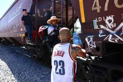 Los ciudadanos entregan botellas de agua a los migrantes que viajan en el tren. (Foto: VAYRON INFANTE / EL SIGLO DE TORREÓN)