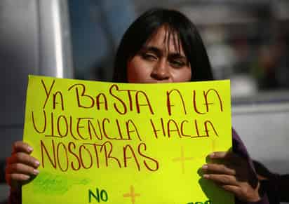 Las activistas pintaron los nombres de mujeres asesinadas en cruces colocadas en el monumento el Umbral del Milenio. (EFE)