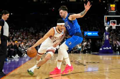 Devin Booker, de los Suns de Phoenix, esquiva a Luka Doncic, de los Mavericks de Dallas, en el partido de la NBA, el lunes 25 de diciembre de 2023, en Phoenix. (Foto AP/Rick Scuteri)

