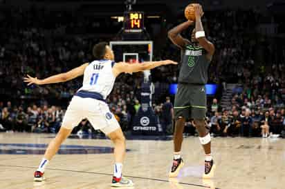 Anthony Edwards, base de los Timberwolves de Minnesota, dispara frente a Dante Exum, de los Mavericks d eDallas, en el partido del jueves 28 de diciembre de 2023 (AP Foto/Matt Krohn)