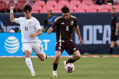 El exjugador de Santos Laguna, Gerardo Arteaga (d) formado en la cantera albiverde, disputa el balón con de Facundo Pellistri de Uruguay, en el amistoso internacional en estadio Empower Field en Mile High en Denver.