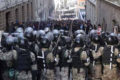 Integrantes de la Policía Militar se forman frente a simpatizantes del presidente Luis Arce durante una protesta contra los militares que tomaron la sede del Gobierno de Bolivia. (EFE)