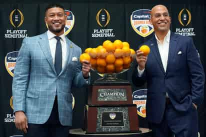 Los coaches Marcus Freeman (Notre Dame, izquierda) y James Franklin (Penn State) posaron ayer junto al tazón que estará en disputa. (AP)