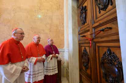 El camarlengo del Colegio Cardenalicio Kevin Farrell (c) y el cardenal secretario de Estado de la Santa Sede Pietro Parolin (i) y el y el sustituto de la secretaria de Estado Edgar Peña Parra (d) sellando la habitación del Papa Francisco en Santa Marta. El papa vivió los doce años de su pontificado en el apartamento 201, en el segundo piso de esta residencia donde también se quedan algunos de los cardenales durante el cónclave. (ARCHIVO)