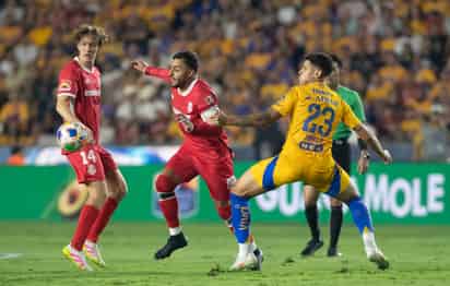 El brasileño Rómulo Zanré de Tigres disputa un balón con Alexis Vega de Toluca en el estadio Universitario.