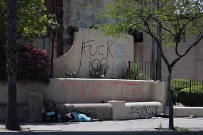 Una persona sin hogar duerme entre grafitis que atacan al Servicio de Inmigración y Control de Aduanas (ICE) durante las protestas provocadas por las redadas migratorias en Los Ángeles, California, el 10 de junio de 2025.