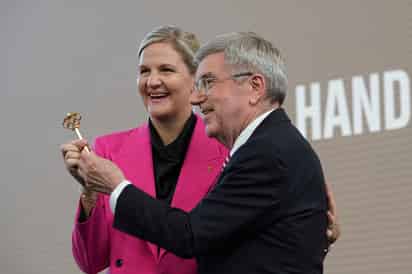 El ahora exdirigente, el esgrimista alemán Thomas Bach, entrega una llave simbólica de la presidencia a la exnadadora zimbabuense, electa en marzo pasado, en la ceremonia de sucesión que tuvo lugar en la Casa Olímpica que está ubicada en Lausana, Suiza.