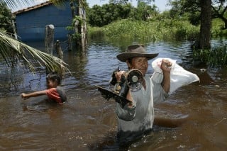 Un hombre y un niño rescatan sus pertenencias en una población cercana a la Trinidad, luego de ser afectados por las inundaciones que azotan la amazonía boliviana. (EFE) 
