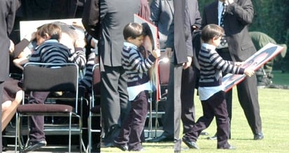 El pequeño Juan Camilo se aferra a la fotografía de su padre Juan Camilo Mouriño, al término del homenaje póstumo que en su honor se efectuó la mañana de ayer en el Campo Marte de la Ciudad de México.