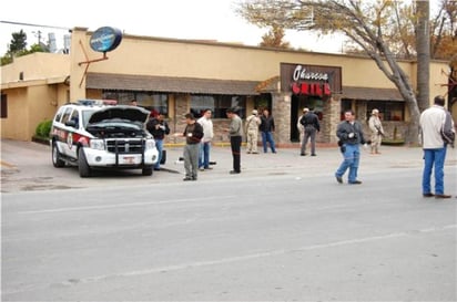 Ataque. Policías acordonan el área afuera del restaurante donde estaba Torres Charles. Una patrulla resultó baleada.