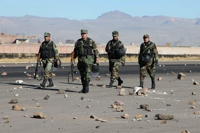 Violencia. Militares caminan por una de las carreteras que fue bloqueada por los manifestantes.