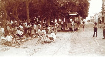 ¿Qué les parece la Plaza de Lerdo con su avenidaMadero viendo al sur? ¿Y qué impresión tienen del tranvía de mulita y los vendedores ambulantes de frutas? Es el arbolado y romántico Lerdo a finales del siglo XIX, donde vivió como uno más de sus habitantes el poetaManuel José Othón, en pleno Porfiriato.