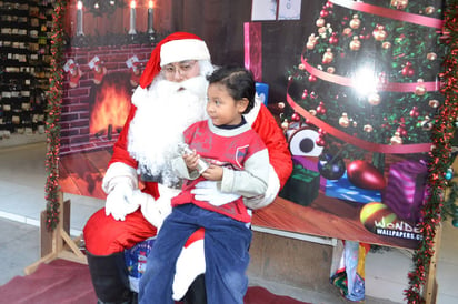 Felicidad. Santa disfruta su trabajo y los niños aprovechan para hacerle sus peticiones. 