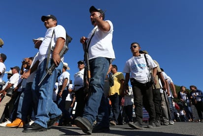 Desfilan. Grupos de autodefensas marcharon ayer custodiados por militares, celebrando el aniversario del movimiento.