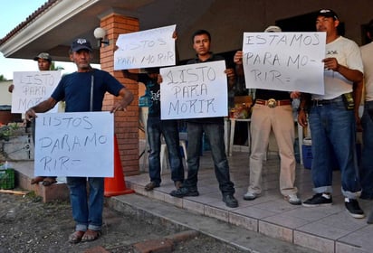 Atrincherados. Autodefensas muestran carteles al interior del rancho donde se encuentran para evitar una confrontación.